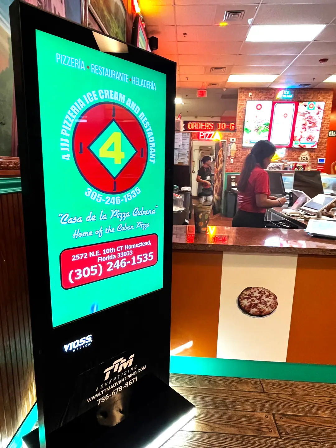 Publicidad DOOH en pantalla digital dentro de la pizzería 4JJJJ Pizza en Homestead, Florida